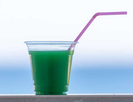 Green cocktail in a glass with a straw. close-up