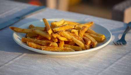 French fries in a plate on a table in a restaurant.の写真素材