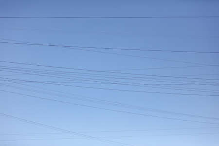 Electric wires against the blue sky.
