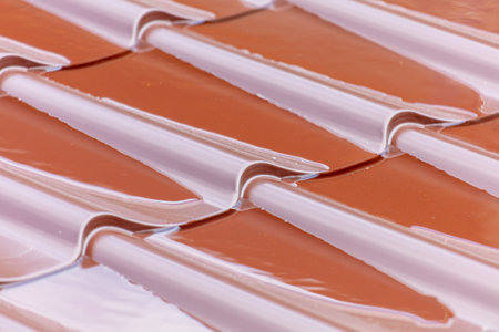 Water on the brown metal roof of the roof of the house. background