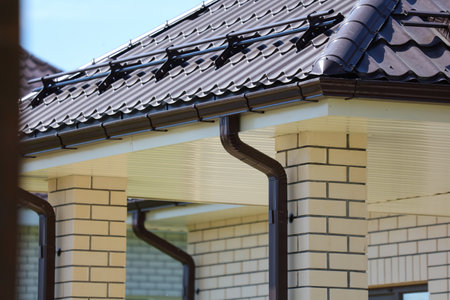 Brown metal gutter on the roof of the houseの写真素材