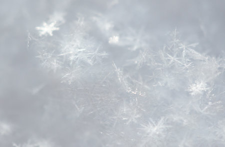 Small white snowflakes in winter as a background. close-up