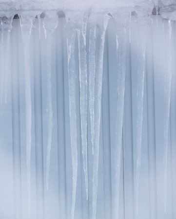 Icicles hang from the roof of the house. Winterの写真素材