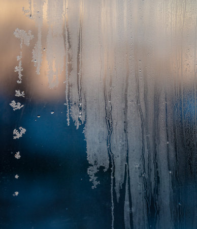 Frozen water on glass at sunrise. close-up.