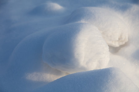 White fluffy snow on the ground as a background. Winter