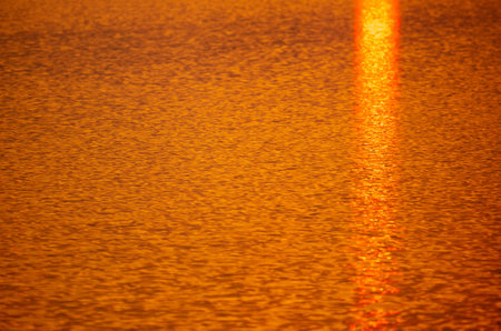 Golden expansion of water at sunset. backgroundの写真素材