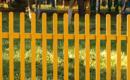 Wooden fence painted with yellow paint. backgroundの写真素材