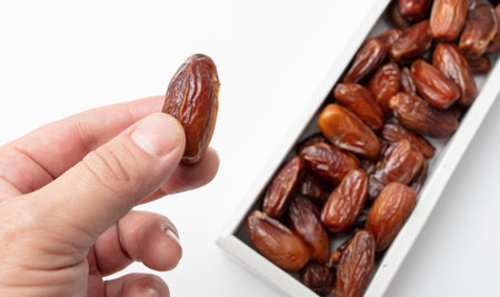 Dried date in hand isolated on white background. close-up