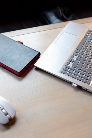 Laptop with notebook on the table