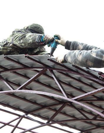 Workers cover the canopy with metal sheets. Technologyの写真素材
