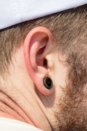 Black earring in a man's ear. close-upの写真素材
