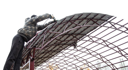 The worker sets the metal sheets on the weight. Technologyの写真素材
