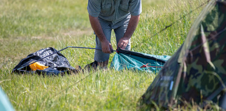 A man is putting together a tent in the park. Natureの写真素材