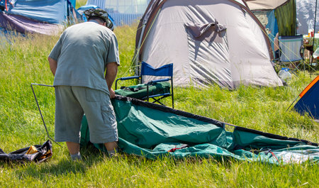 A man is putting together a tent in the park. Natureの写真素材