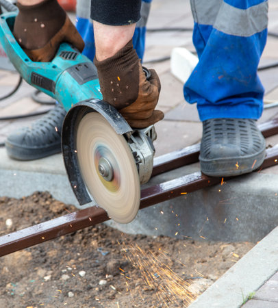 A worker cuts metal at a construction site. Technologiesの写真素材