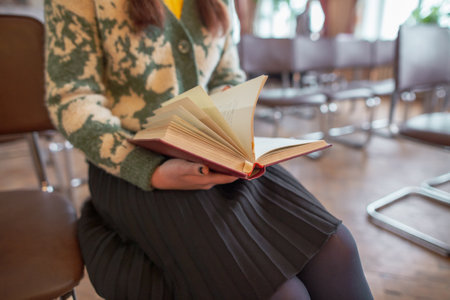 Girl student with a book sits on a chair. Educationの写真素材