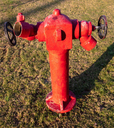Red fire hydrant on the lawn in the park.
