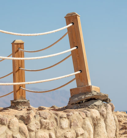 Fence with wooden railing against the blue sky.の写真素材