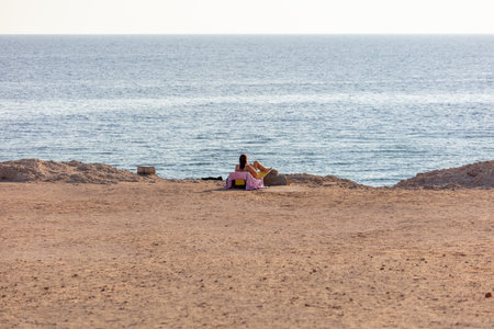 Girl in a bathing suit on a beach chair by the sea. relaxationの写真素材