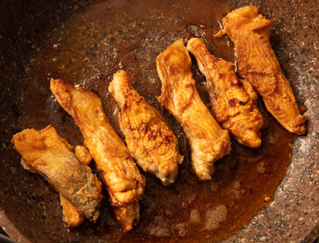The fish is fried in a frying pan in oil. close-up.の写真素材