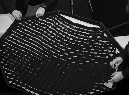 Installing a honeycomb filter on a flash in a photo studio.
