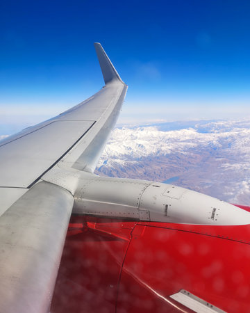 Airplane wing in flight view from the porthole.の写真素材
