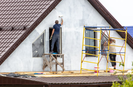 Workers are priming outside the walls of the house. constructionの写真素材