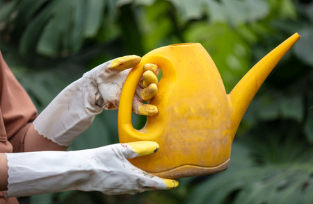 Girl watering plants from a watering can in the park. Natureの写真素材