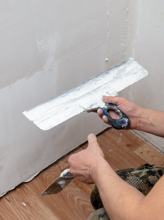 A man is plastering a wall in the house.の写真素材