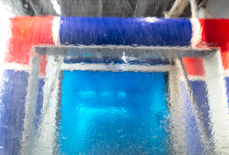 Wet glass on a car in a car wash. background.の写真素材