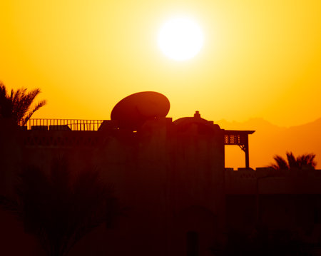 House roof silhouette with satellite dishes at sunset. backgroundの写真素材