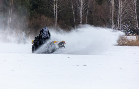 Quad bike rides on white snow in winter. Sportの写真素材