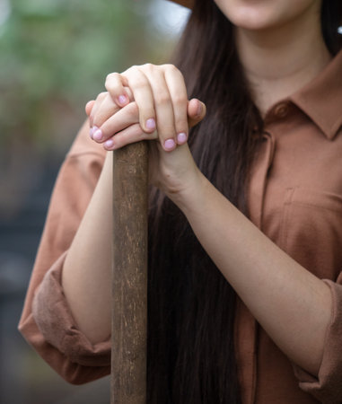 Girl's hands on the handle of a shovel. close-upの写真素材