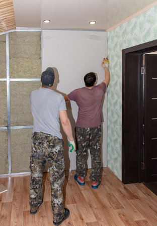 Workers install a plasterboard wall.の写真素材