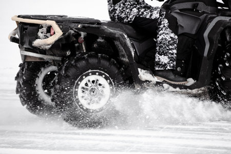 Quad bike rides on white snow in winter. Sport