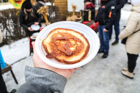 Pancake with honey in a plate in hand.の写真素材