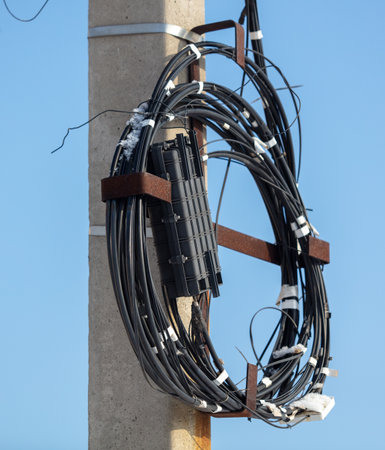 Electric wire on a pole against the blue sky.