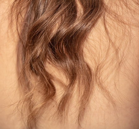 Wavy blond hair on the shoulders of the girl's back. close-up.の写真素材
