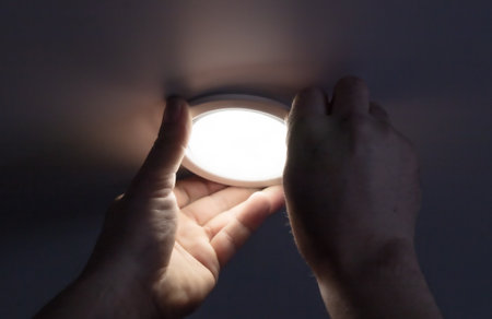 Installation of a light bulb in a stretch ceiling.