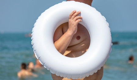 A man with a white rubber ring on the sea.の写真素材