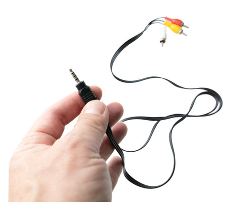 Audio Jack on a wire in a hand isolated on a white background.の写真素材