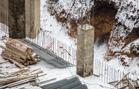 Concrete blocks for the foundation in the snow in winter at a construction site.