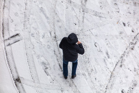 A man walks on white snow in winter. view from above.の写真素材