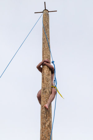 A man climbs a wooden pole. Shrovetide holidayの写真素材
