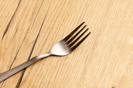Fork on the wooden table, closeup shot, shallow depth of field.の写真素材