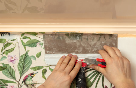 A worker pastes wallpaper on the walls in a room.の写真素材