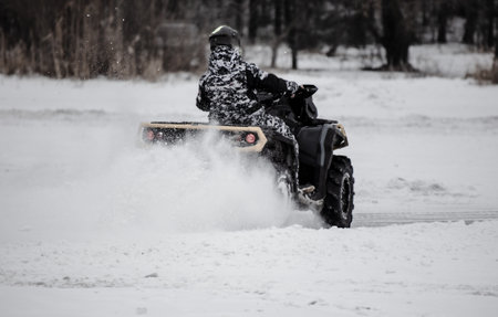 Quad bike rides on white snow in winter. Sportの写真素材