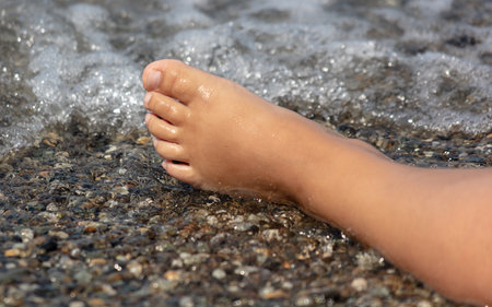 Man's foot on a pebble beach.の写真素材