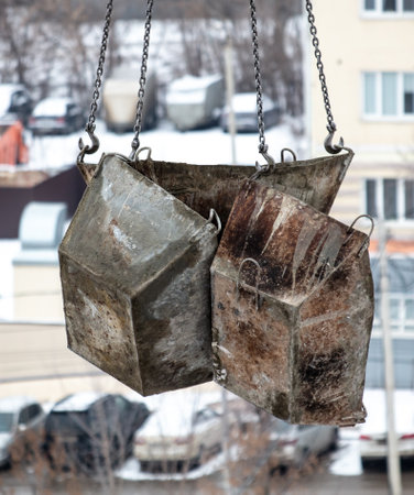 Crane lowers containers for concrete at a construction site.の写真素材