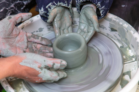Hands of a potter, creating an earthen jar.